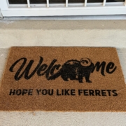 Welcome mat with an image of a ferret and the words, welcome, hope you like ferrets.